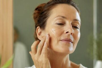Femme appliquant de l'aloe vera pour peau déshydratée sur sa joue, dans sa salle de bain